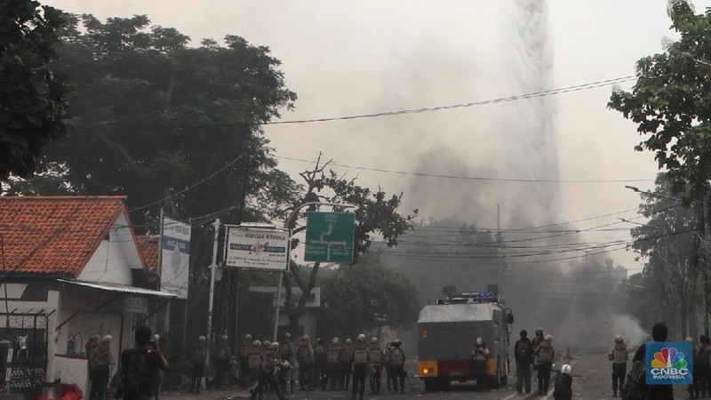 Helikopter Kementerian Perhubungan menyiram massa di kawasan KS Tubun, Jakarta, Rabu (22/5). Pihak berwajib membubarkan massa dengan helikopter.