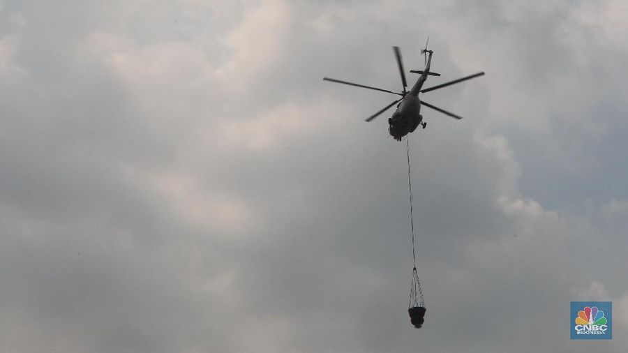 Helikopter Kementerian Perhubungan menyiram massa di kawasan KS Tubun, Jakarta, Rabu (22/5). Pihak berwajib membubarkan massa dengan helikopter.