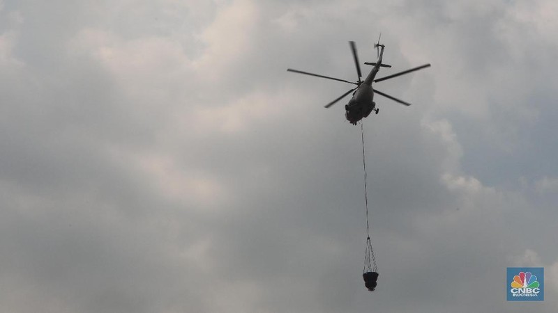 Helikopter Kementerian Perhubungan menyiram massa di kawasan KS Tubun, Jakarta, Rabu (22/5). Pihak berwajib membubarkan massa dengan helikopter.