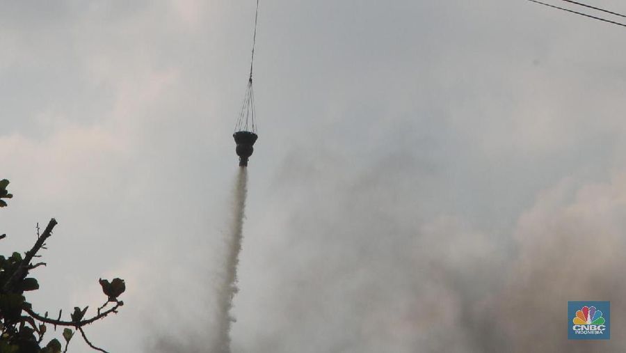 Helikopter Kementerian Perhubungan menyiram massa di kawasan KS Tubun, Jakarta, Rabu (22/5). Pihak berwajib membubarkan massa dengan helikopter.