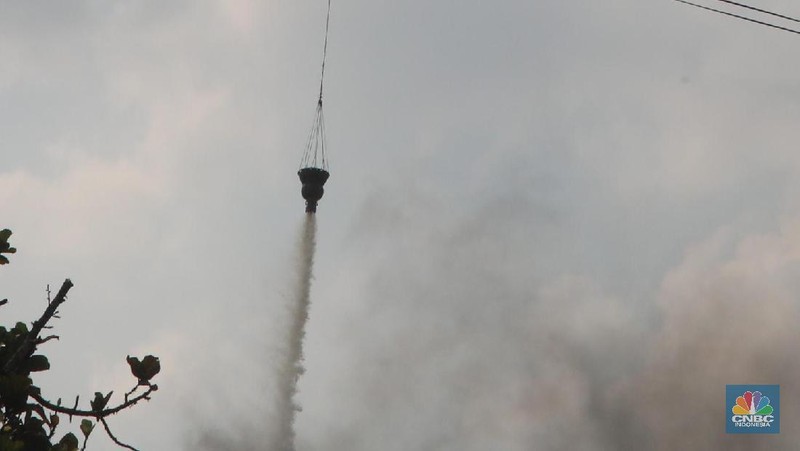 Helikopter Kementerian Perhubungan menyiram massa di kawasan KS Tubun, Jakarta, Rabu (22/5). Pihak berwajib membubarkan massa dengan helikopter.