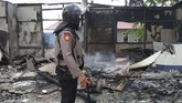 Seorang anggota Dit Sabhara Polda Kalbar bersiaga di depan pos polisi yang telah dibakar massa di Tanjung Raya, Pontianak, Kalimantan Barat, Rabu (22/5). (ANTARA FOTO/Jessica Helena Wuysang)