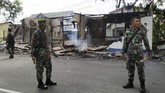 Tiga anggota TNI AD berdiri di depan pos polisi yang telah dibakar massa di Tanjung Raya, Pontianak, Kalimantan Barat, Rabu (22/5). (ANTARA FOTO/Jessica Helena Wuysang)