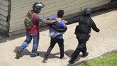 Dua petugas kepolisian menggiring seorang terduga provokator saat terjadi keributan yang dilakukan sekelompok warga di Jembatan Kapuas di Pontianak, Kalimantan Barat, Rabu (22/5). (ANTARA FOTO/Jessica Helena Wuysang).