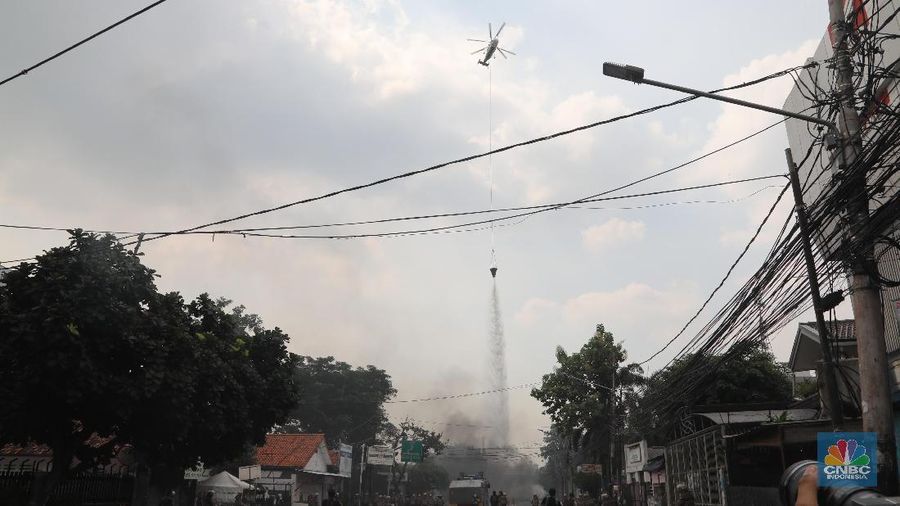 Helikopter Kementerian Perhubungan menyiram massa di kawasan KS Tubun, Jakarta, Rabu (22/5). Pihak berwajib membubarkan massa dengan helikopter.