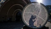 Seorang pria dengan ponselnya saat berdiri di belakang peta jalan di luar stasiun metro Krasnye Vorota di Moskow, Rusia. (AFP/Yuri Kadobnov)