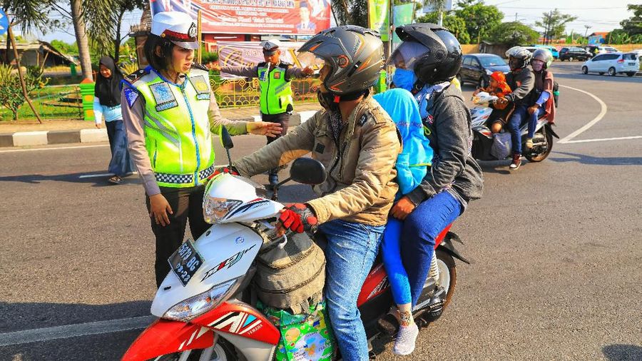 Petugas polisi wanita memberhentikan pemudik motor di Kawasan Cirebon, Jawa Barar, Rabu (29/5/2019). (CNBC Indonesia/Andrean Kristianto)