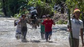 Warga mengungsi ke tempar-tempat aman membawa harta benda yang bisa diselematkan. Tampak sejumlah warga memanggul sepeda motor saat menyeberangi arus air banjir bandang yang melanda Desa Tuva, Kecamatan Gumbasa, Kabupaten Sigi. (ANTARA FOTO/Basri Marzuki/wsj).