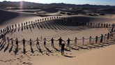Lebih dari 50 orang mengikuti kelas yoga di padang pasir Samalayuca di Juarez, Chihuahua, Meksiko, pada Sabtu (25/5) lalu. (Photo by Herika MARTINEZ / AFP)