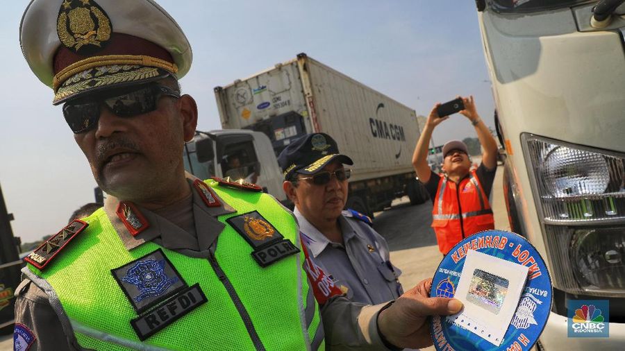 Kakorlantas Polri Irjen Refdi Andri menempelkan striker khusus di kaca truk di GT Cikampek Utama I, Cikampek, Kamis (30/5/2019). (CNBC Indonesia/Andrean Kristianto)
