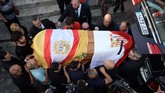 Peti Antonio Reyes yang dibalut bendera desa Utrera and Sevilla FC dimasukkan ke dalam mobil jenazah untuk dibawa ke Gereja Santa Maria de Mesa di Utrera, sebelum dimakamkan. (Photo by CRISTINA QUICLER / AFP)