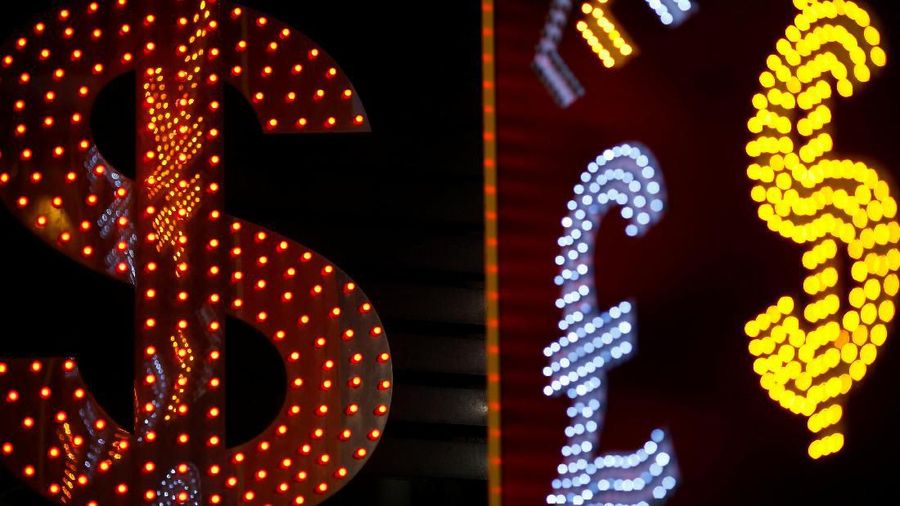 FILE PHOTO: Dollar signs are seen alongside the signs for other currencies at a currency exchange shop in Hong Kong November 1, 2014.  A year-long investigation into allegations of collusion and manipulation by global currency traders is set to come to a head on Wednesday, with Britain's financial regulator and six big banks expected to agree a settlement involving around £1.5 billion ($2.38 billion) in fines. The settlement comes amid a revival of long-dormant volatility on foreign exchanges, where a steady rise in the U.S. dollar this year has depressed oil prices and the currencies of many commodity exporters such as Russia's rouble, Brazil's real and Nigeria's naira - setting the scene for more turbulence on world financial markets in 2015. Picture taken November 1, 2014. REUTERS/File Photo