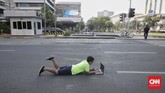 Jalanan di Jakarta yang lengang saat Lebaran dimanfaatkan warga untuk berfoto dengan aksi-aksi yang nyeleneh. (CNN Indonesia/Adhi Wicaksono)