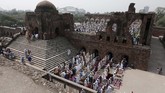 Kalau biasanya salat Idul Fitri dilangsungkan di masjid yang masih kokoh berdiri, masyarakat di India berbondong-bondong salat di puing-puing Feroz Shah Kotla, benteng yang dahulu didirikan oleh Sultan Feroz Shah Tughlaq pada tahun 1300-an. (REUTERS/Adnan Abidi)