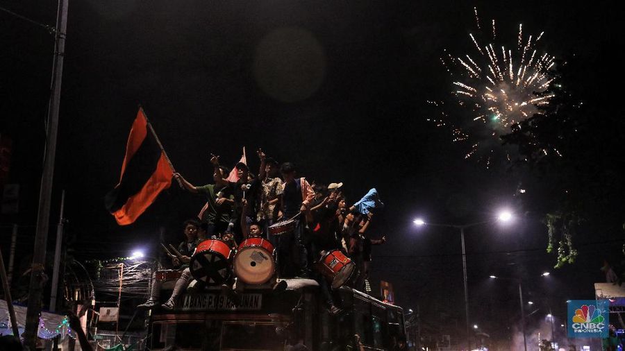 Warga memukul bedug saat merayakan malam takbiran di Kawasan Tanah Abang, Jakarta Pusat, Selasa (4/6/2019). Sejunlah Ratusan warga sekitar Tanah Abang merayakan malam takbiran dengan memukul bedug, menyalakan petasan dan kembang api. Tradisi ini selalu dilakukan setiap malam takbiran. Mereka tak henti-hentinya menyalakan kembang api dan petasan. Mereka ada juga yang keliling dengan menggunakan bis. Tradisi ini diikuti oleh berbagai macam usia baik pria mau pun wanita. Lalu lintas disekitar lokasi macet karena mereka memberhentikan mobil ketika ingin menyalakan petasan.  (վ/Andrean Kristianto)