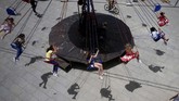 Pada hari pertama Idul Fitri, anak-anak menikmati ayunan permainan kursi putar di Sidon, Libanon. (REUTERS/Ali Hashisho)