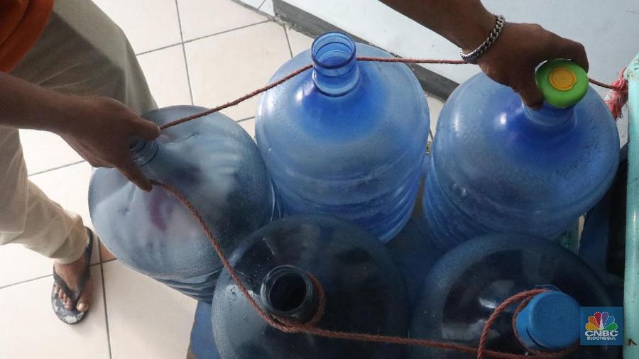 Pedagang air galon membawa galon yang sudah diisi penuh untuk dijual ke warga apartemen di Kawasan Pluit, Jakarta, Rabu (12/6). Banyak penghuni apartemen di kawasan tersebut menggunakan air galon isi ulang untuk mandi. Mumun seorang pembantu rumah tangga mengatakan majiakannya bisa menkonsumsi air galon sehari 4-5 galon untuk mandi dan cuci piring. Harga galon isi ulang ia beli seharga Rp 3500 yang berasal dari air pam, Rp 7000 untuk galon isi ulang untuk galon asli Rp.20.000. Banyak penghuni apartmen menggunakan air galon karena air yang mereka tempati kadang bau dan kotor. (CNBC Indonesia/Muhammad Sabki)