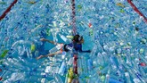Seorang bocah berenang di suatu kolam yang penuh botol pastik. Ia turut serta dalam aksi mengampanyekan Hari Lautan Sedunia di Bangkok. (AFP/Romeo Gacad)