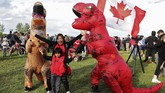 Pendukung Toronto Raptors, Marietta Villostas dan putranya Max, merayakan keberhasilan tim asuhan Nick Nurse jadi juara NBA 2019 bersama maskot tim di Calgary, Alberta, Canada, Jumat (14/6). (REUTERS/Todd Korol)