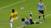 Edinson Cavani menyepak bola sambil menjatuhkan badan untuk mencetak gol kedua Uruguay pada menit ke-33 setelah menerima umpan dari Diego Godin. (REUTERS/Washington Alves)