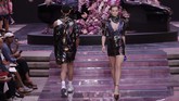 Versace bermain dengan campuran bahan dan warna. Jas dua motif, blazer, jaket, motif leopard, dan atasan berkilau dengan bubuhan tanda-tangan Gianni Versace. (AP Photo/Luca Bruno)