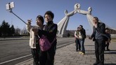 Sekelompok turis asal China berfoto di depan monumen Tiga Piagam (Three Charters) di Pyongyang, Korea Utara. Turis China semakin ramai terlihat di negara pimpinan Kim Jong Un ini.