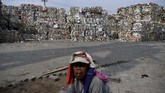 Seorang pekerja beraktivitas di dekat tumpukan sampah kertas yang diimpor sebuah perusahaan pabrik kertas sebagai bahan baku kertas di Mojokerto, Jawa Timur, Rabu (19/6). (ANTARA FOTO/Zabur Karuru)
