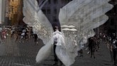Bayangan pejalan kaki dan turis yang berkumpul di lapangan Pantheon di Roma tercermin di kaca jendela suatu hotel yang berhiaskan sayap malaikat. (AP Photo/Gregorio Borgia)