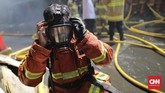 Petugas Damkar menggunakan masker sebelum bekerja menjinakkan api yang menjilat gudang kembang api di Pasar Pagi, Jalan Asemka, Roa Malaka, Tambora, Jakarta Barat, 21 Juni 2019 pagi. Kebakaran itu dilaporkan terjadi mulai pukul 10.55 WIB. (CNN Indonesia/Adhi Wicaksono)