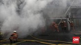 Petugas menyemprotkan air ke arah gudang, yang merupakan bangunan tiga lantai itu guna memadamkan api yang membakar. (CNN Indonesia/Adhi Wicaksono)