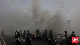 Warga di atas jalan layang menyaksikan upaya petugas pemadam kebakaran memadamkan api yang menjilat sebuah kembang api di Pasar Pagi, Jalan Asemka, Jakarta Barat. (CNN Indonesia/Adhi Wicaksono)