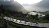 Penggemar berlatih yoga di Desa Qiqi, Zhengjiajie, Hunan, China dalam rangka merayakan Hari Yoga Internasional. (Photo by STR / AFP)