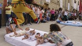 Para bayi yang dilompati tersebut harus berusia 12 bulan setelah dilahirkan, untuk bisa bergabung dalam tradisi El Colacho ini. (CESAR MANSO / AFP)