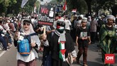 Massa aksi menunjukan poster dan alat peraga yang dibawa dalam kegiatan mengawal sidang putusan sengketa Pilpres 2019 di Mahkamah Konstitusi (MK) di kawasan Jalan Medan Merdeka Barat, Jakarta, 27 Juni 2019. (CNN Indonesia/Andry Novelino)