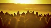Orang-orang datang untuk melihat matahari terbit di Stonehenge di Wiltshire, Inggris, dan merayakan hari terpanjang dalam satu tahun. (Ben Birchall/PA via AP)