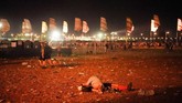 Sepasang penonton tak sungkan tidur di tengah lapangan usai menyaksikan konser di Glastonbury Festival 2019. (REUTERS/Henry Nicholls)