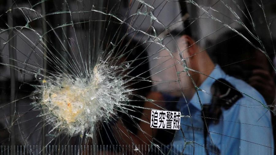 Petugas kepolisian berjaga di depan pintu masuk di gedung Legislatif usai benterok terjadi malam hari di Hong Kong.