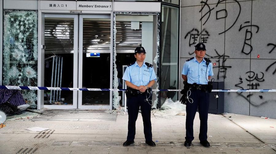 Petugas kepolisian berjaga di depan pintu masuk di gedung Legislatif usai benterok terjadi malam hari di Hong Kong.