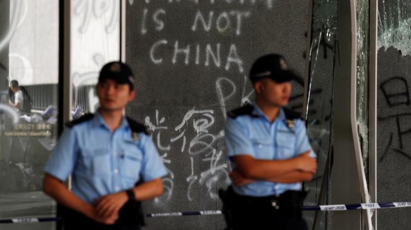 Petugas kepolisian berjaga di depan pintu masuk di gedung Legislatif usai benterok terjadi malam hari di Hong Kong.
