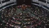 Ruang sidang di gedung parlemen Hong Kong juga tidak luput dari serbuan para demonstran. Mereka berdiri di atas meja sambil meneriakkan slogan anti pemerintah. (AP Photo/Kin Cheung)