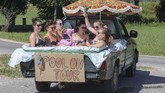 Di Unlingen, Jerman bagian selatan, enam perempuan mendinginkan badan di air di suatu bak mobil pick-up yang dilapisi plastik. Jerman adalah satu dari beberapa tempat yang diterpa gelombang panas pada pekan ini. (Thomas Warnack/dpa via AP)