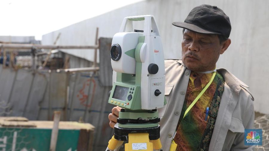 Sejumlah pegawai dari Badan Pertahanan Nasional (BPN) melakukan pengukuran di titik nol (awal) proyek tanggul laut raksasa lanjutan National Capital Integrated Coastal Development (NCICD) tahap dua di kawasan Cilincing, Jakarta Utara, Kamis (4/7). (CNBC Indonesia/Andrean Kristianto)