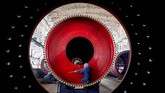 Seorang pegawai mengukur mesin giling yang baru saja diproduksi di suatu pabrik di Nantong, Provinsi Jiangsu, China. (REUTERS/Stringer)