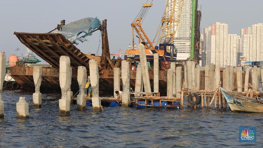 Pekerja menyelesaikan pembangunan dermaga yang dilengkapi pemecah ombak di Kawasan Kali Adem, Muara Angke, Jumat (5/7/2019).