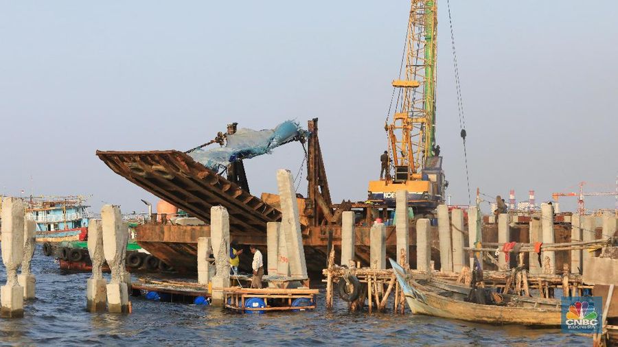 Pekerja menyelesaikan pembangunan dermaga yang dilengkapi pemecah ombak di Kawasan Kali Adem, Muara Angke, Jumat (5/7/2019).