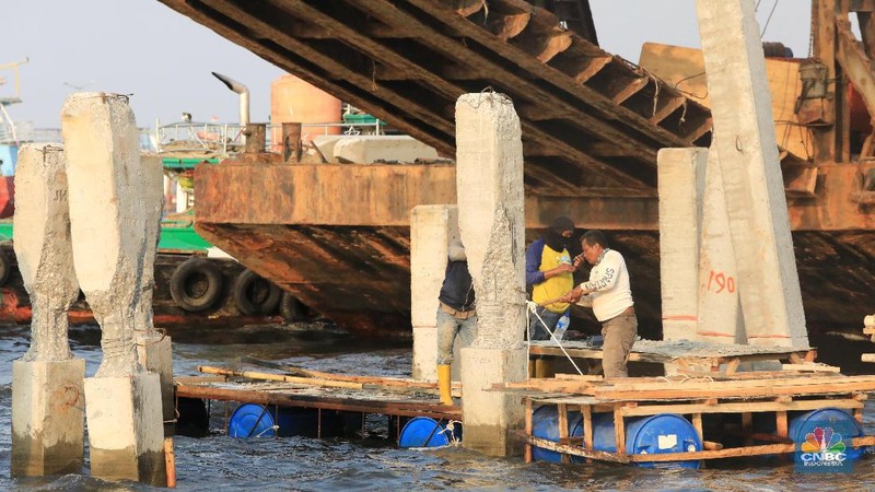 Pekerja menyelesaikan pembangunan dermaga yang dilengkapi pemecah ombak di Kawasan Kali Adem, Muara Angke, Jumat (5/7/2019).
