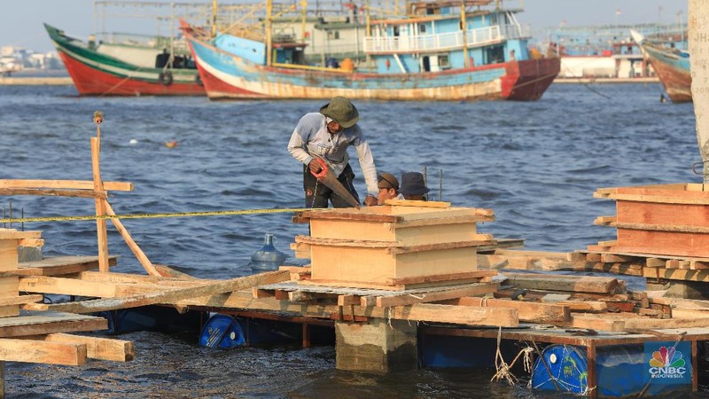 Pekerja menyelesaikan pembangunan dermaga yang dilengkapi pemecah ombak di Kawasan Kali Adem, Muara Angke, Jumat (5/7/2019).