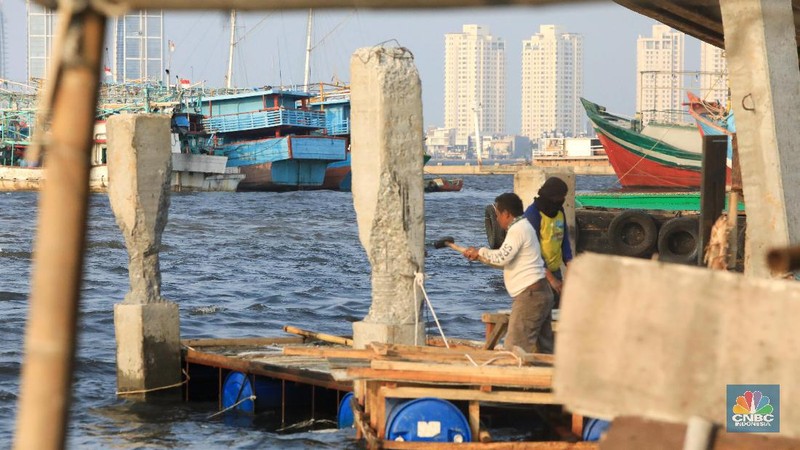 Pekerja menyelesaikan pembangunan dermaga yang dilengkapi pemecah ombak di Kawasan Kali Adem, Muara Angke, Jumat (5/7/2019).