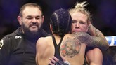 Amanda Nunes berusaha menghibur Holly Holm usai pertarungan gelar juara dunia kelas bantam wanita di UFC 239. (Sean M. Haffey/Getty Images/AFP)