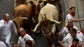 Orang dari seluruh dunia berduyun-duyun membanjiri festival yang menawarkan atraksi manusia dengan banteng ini. (AP Photo/Alvaro Barrientos)